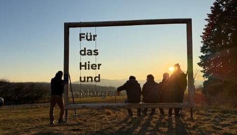 Foto mit Plakatrahmen aus Holz und Sitzbank in der Natur mit Sonnenuntergang und Menschen