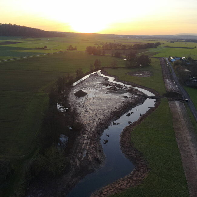 Luftbildaufnahme eines umgestalteten Gewässerlaufs mit neuen Altarmstrukturen und großräumiger Insel