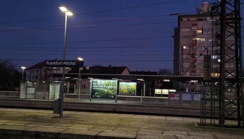 Foto mit Plakat an einer Straßenbahnhaltestelle