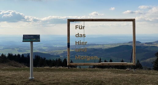 Foto mit Plakatrahmen aus Holz und Sitzbank in der Natur